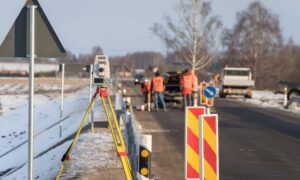 Surveying equipment set up along a paved road for topo survey fieldwork and site measurements