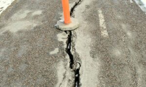 Cracked city sidewalk marked with a safety cone showing why drone surveying is vital for urban infrastructure inspections