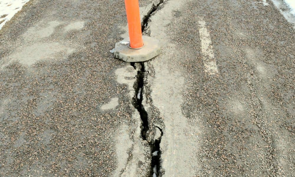 Cracked city sidewalk marked with a safety cone showing why drone surveying is vital for urban infrastructure inspections