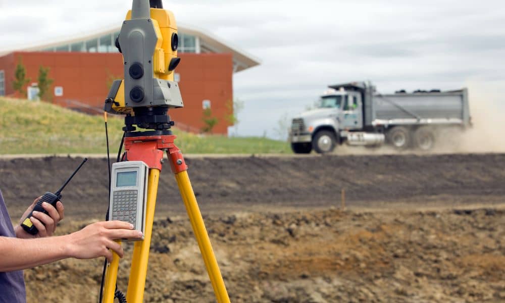 Surveying equipment set up for property surveys to document boundaries and elevations on a building site
