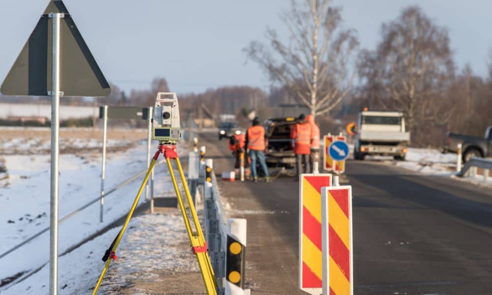Surveyor total station set up on a flood control project site for a topo survey