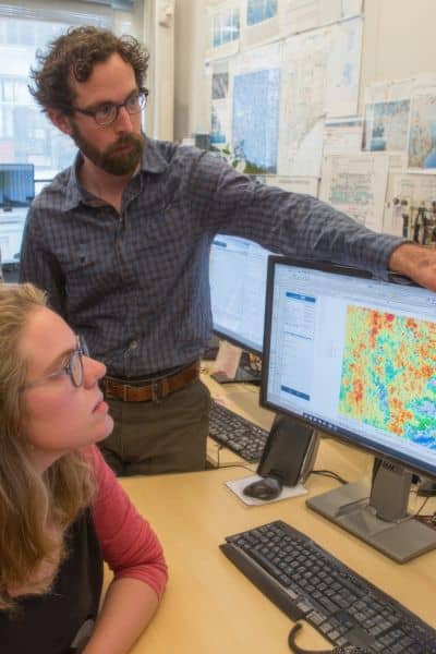 Engineers analyzing drone survey elevation maps and shoreline data to verify site accuracy after a seiche