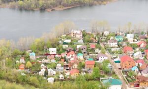 Aerial view of residential homes near a river showing different elevations and potential flood risk areas relevant to FEMA elevation certificate.