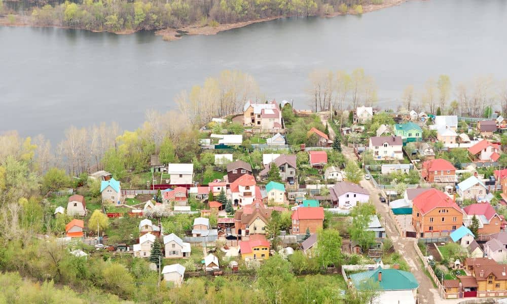 Aerial view of residential homes near a river showing different elevations and potential flood risk areas relevant to FEMA elevation certificate.
