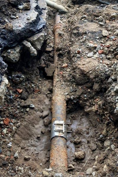 Exposed and deteriorated underground service line uncovered during excavation, showing the risks of working with outdated utility maps
