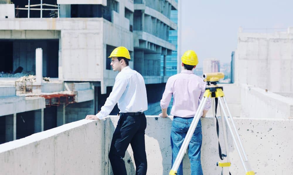 Surveyors reviewing site conditions with a total station during an ALTA Land Title Survey on a commercial property