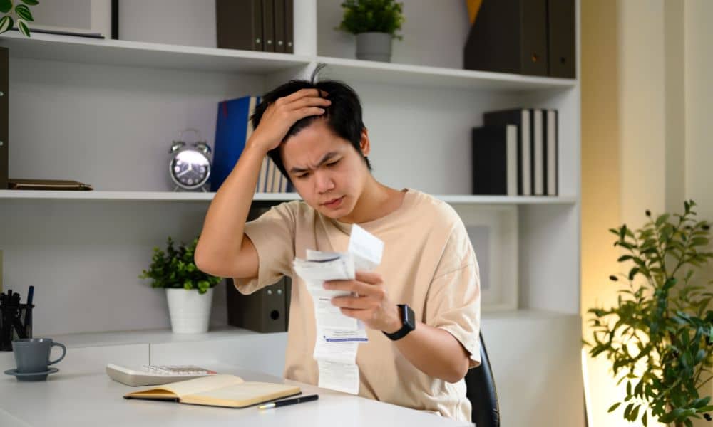 Homeowner stressed while reviewing rising tax bills and considering ordering a property survey